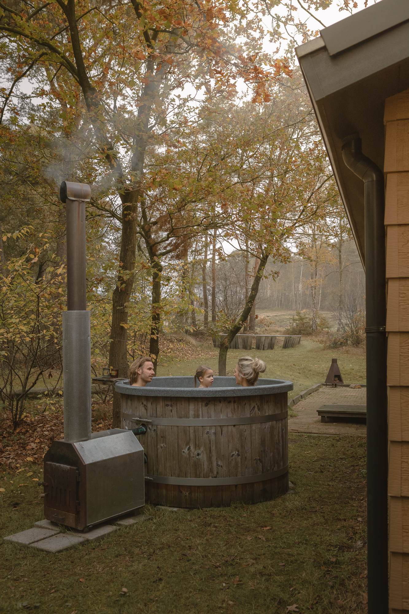 Gezin in hottub bij bungalow in het bos bij Lemeler Esch natuurcamping in Overijssel