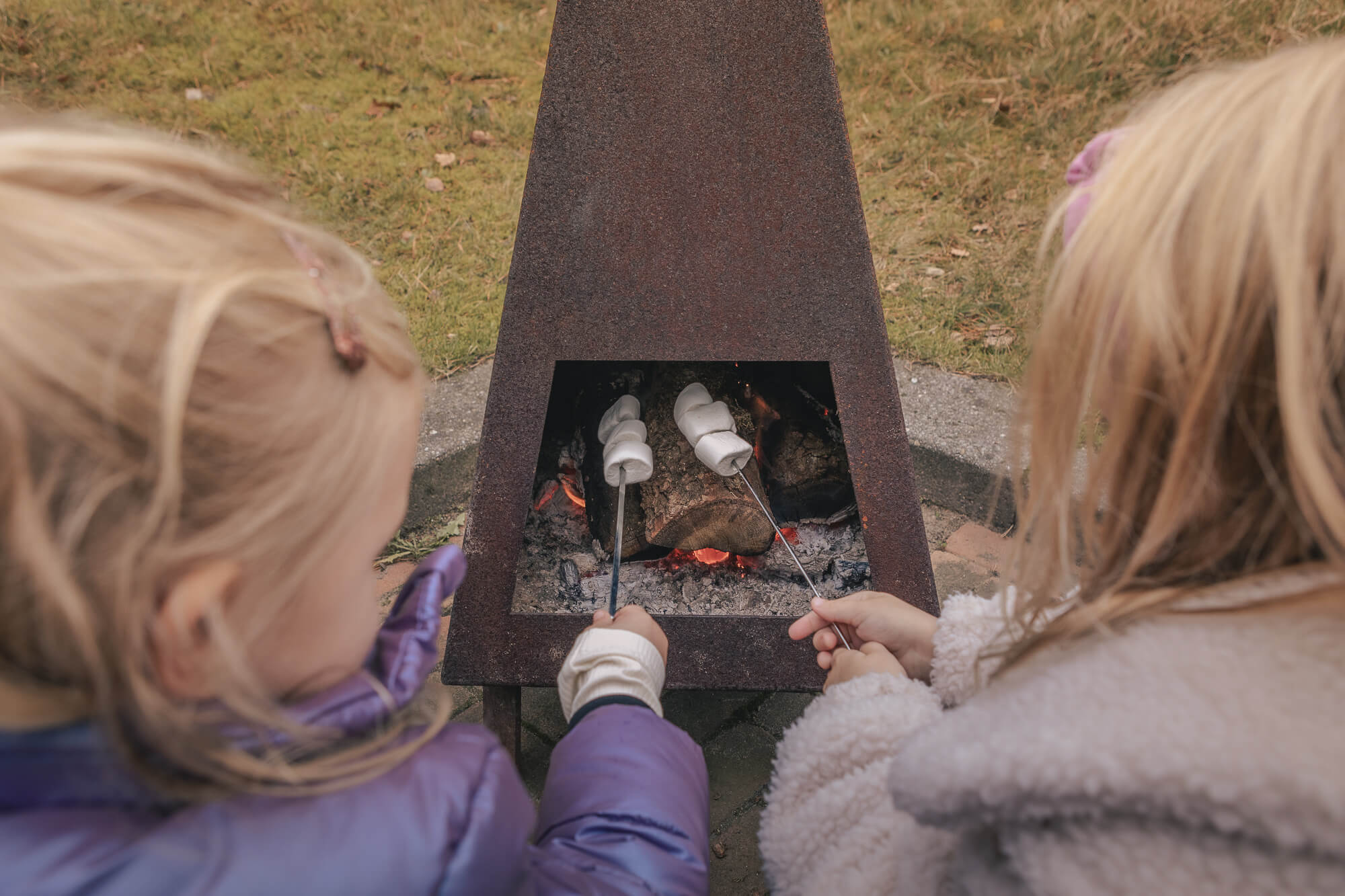 Kinderen marshmallow roosteren bij bungalow aan de bosrand bij Lemeler Esch natuurcamping