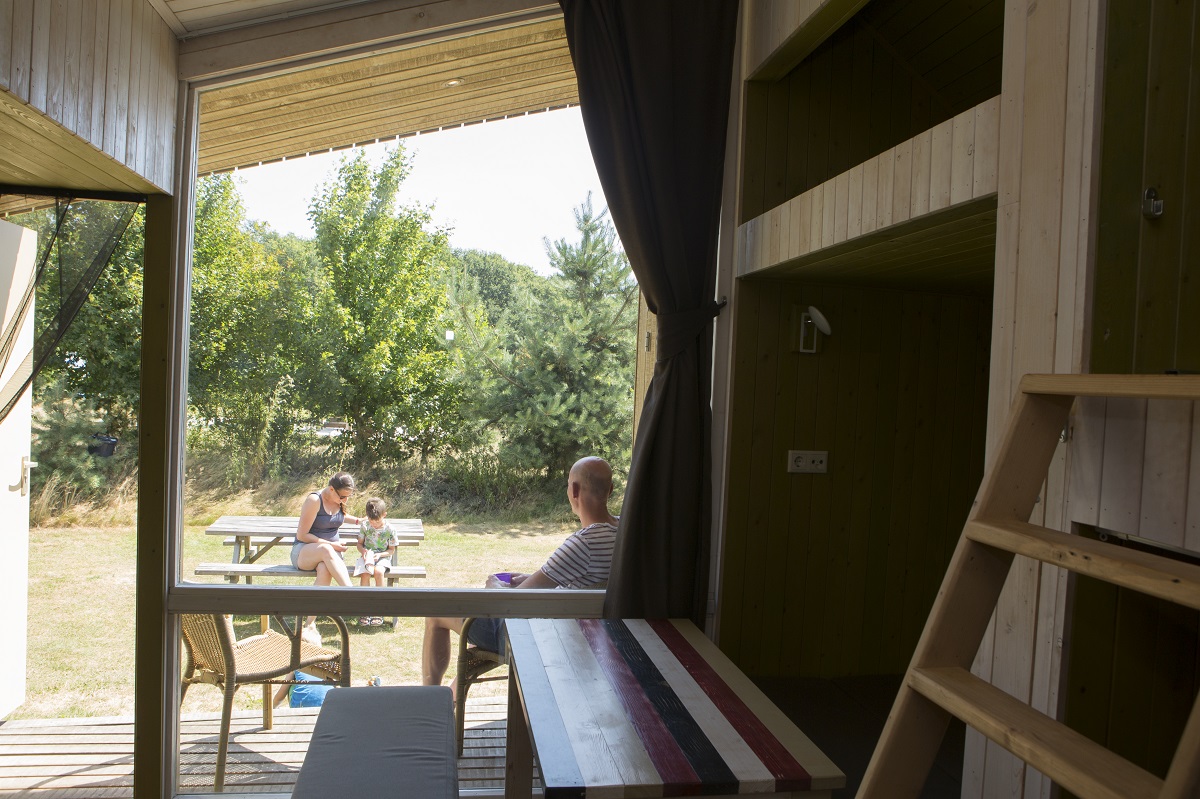 Gezin op terras van de Trek-in natuurhuisje bij Lemeler Esch natuurcamping