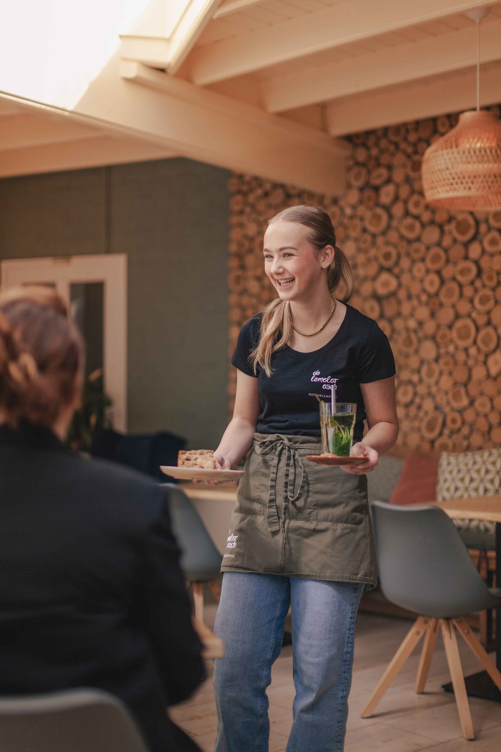 Collega in de serre van Boscafé Lemeler Esch met huisgemaakte taart en verse muntthee in haar hand