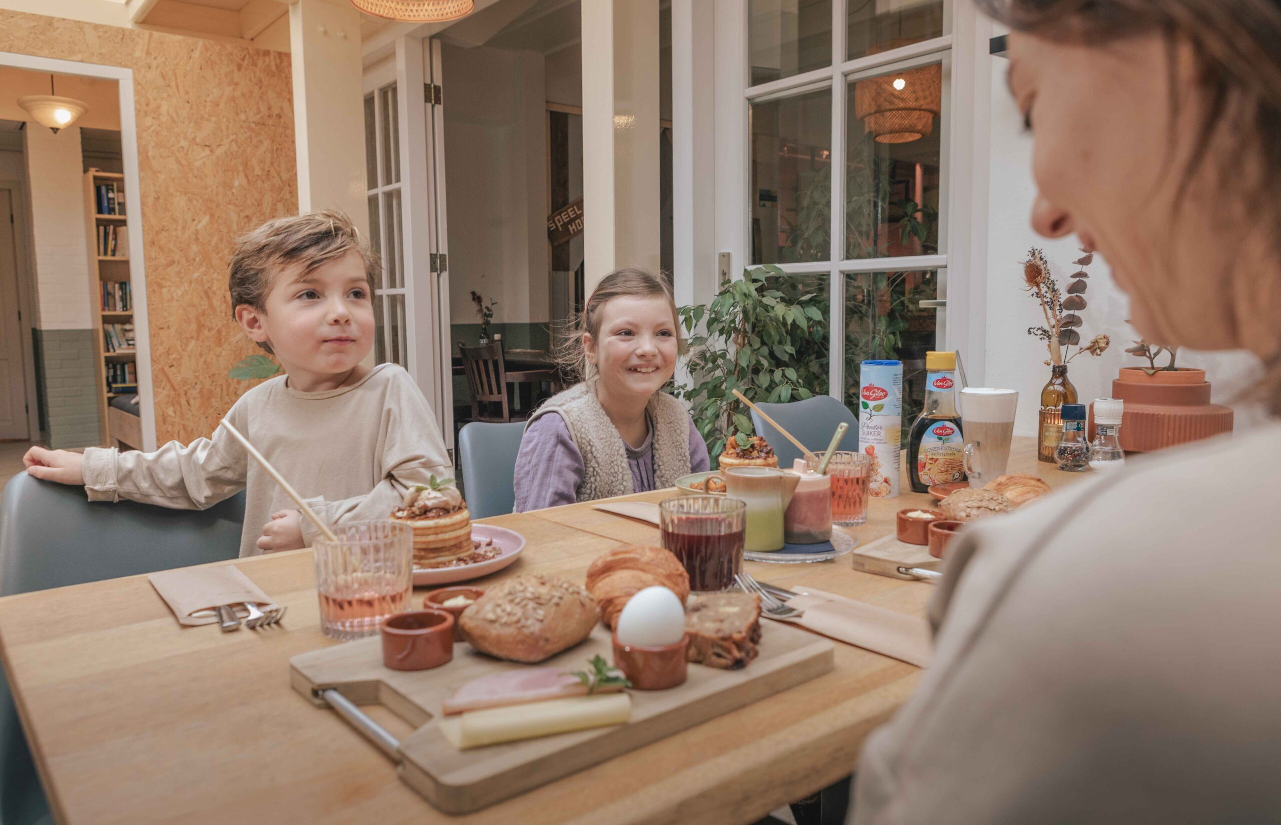 Gezin met ontbijtplank in de serre van Boscafé Lemeler Esch