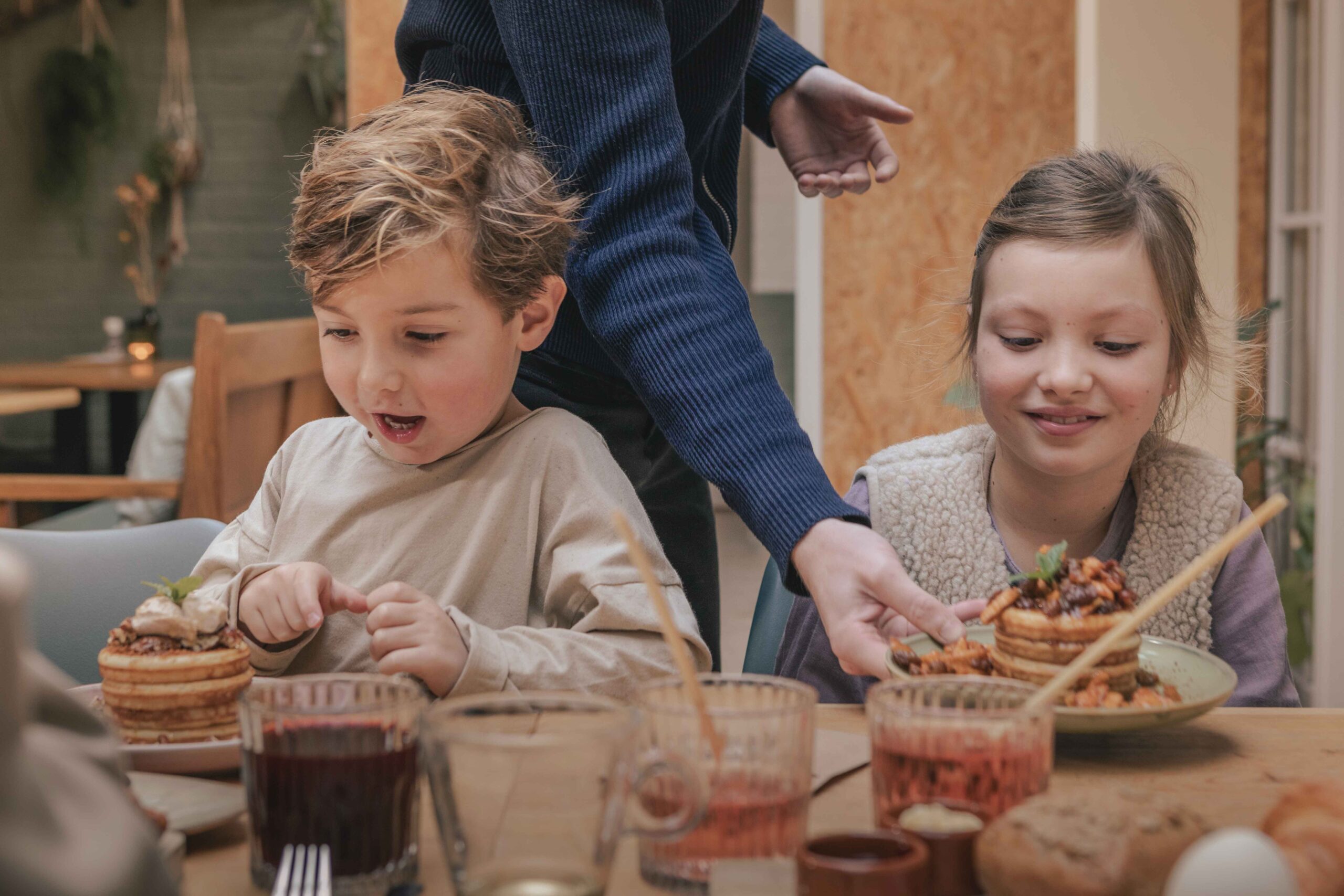 Kinderen krijgen pannenkoekjes geserveerd in de serre van Boscafé Lemeler Esch