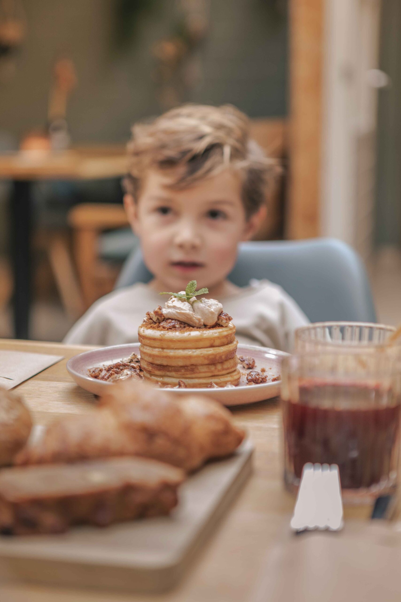 Kind met pannenkoekjes in de serre van het Boscafé Lemeler Esch