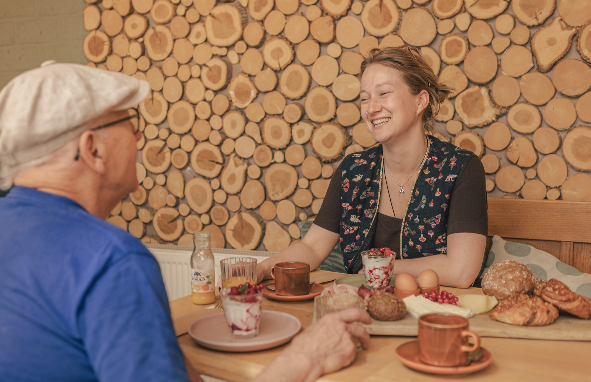 Gasten aan tafel met brunchplank in de serre van Boscafé Lemeler Esch