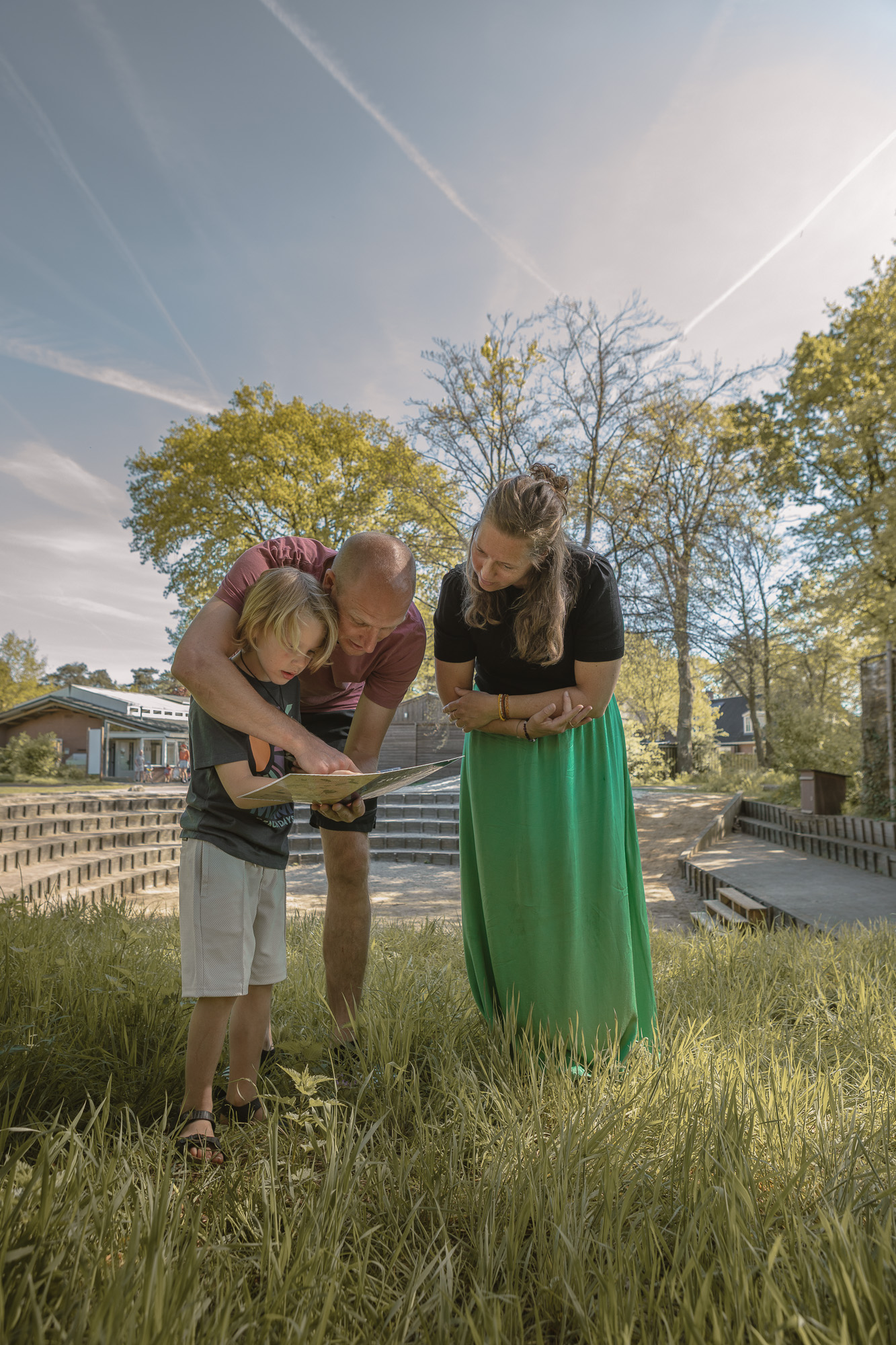 Ouders en kind kijken samen naar zoekkaart bij buitentheater van Lemeler Esch