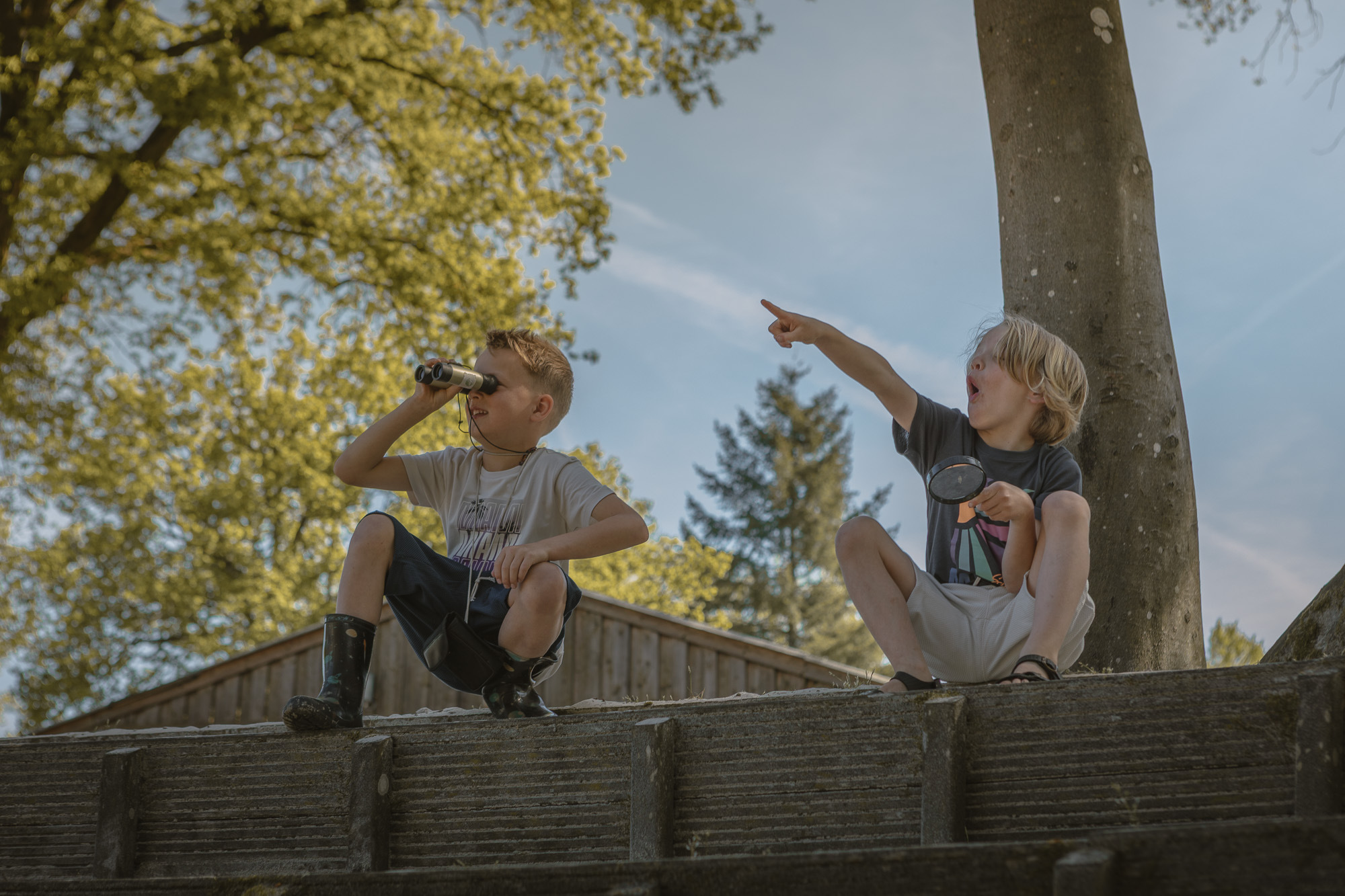 Twee jongens met verrekijker en vergrootglas bij buitentheater Lemeler Esch