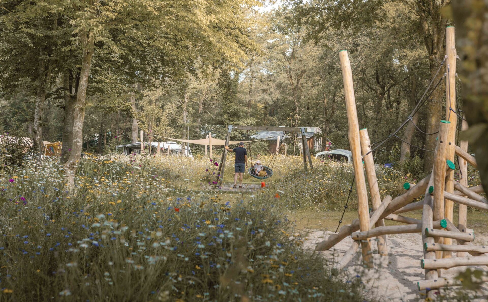 Kinderen op schommel bij kampeerveld Bloemenweide bij Lemeler Esch