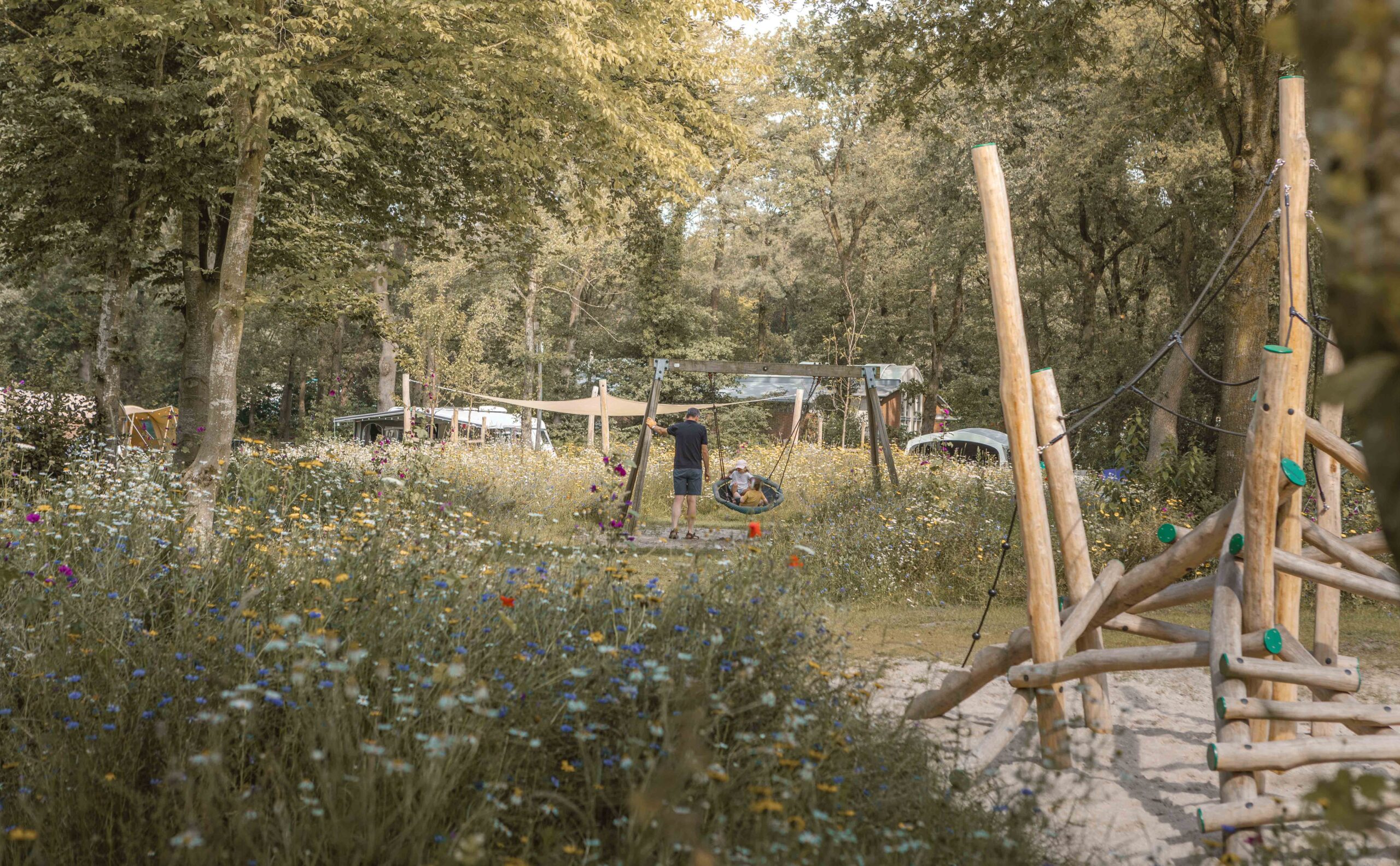 Kinderen op schommel bij kampeerveld Bloemenweide bij Lemeler Esch